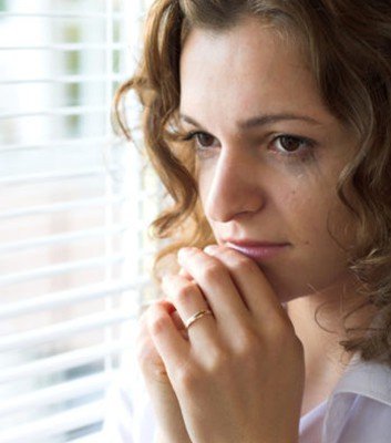 A woman in thought looking out the window.