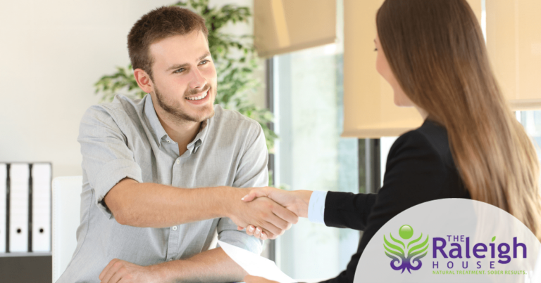 A young man shakes the hand of his boss.