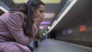 A woman struggling to manage her PTSD triggers at a subway station.