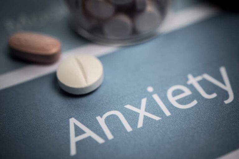 Prescription pills on a table above the word "Anxiety."