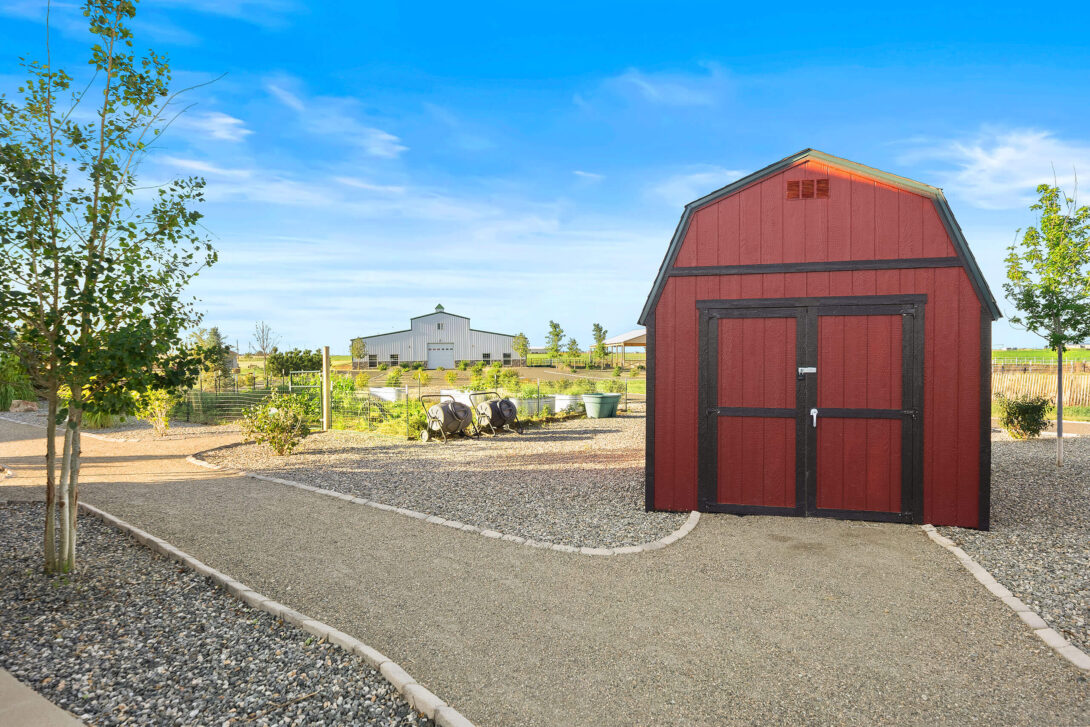 View of the red barn and white building