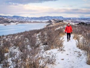 A man hiking in winter landscape at the foothills of the Rocky Mountains in Colorado.