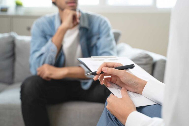 Close up of therapist taking notes with patient