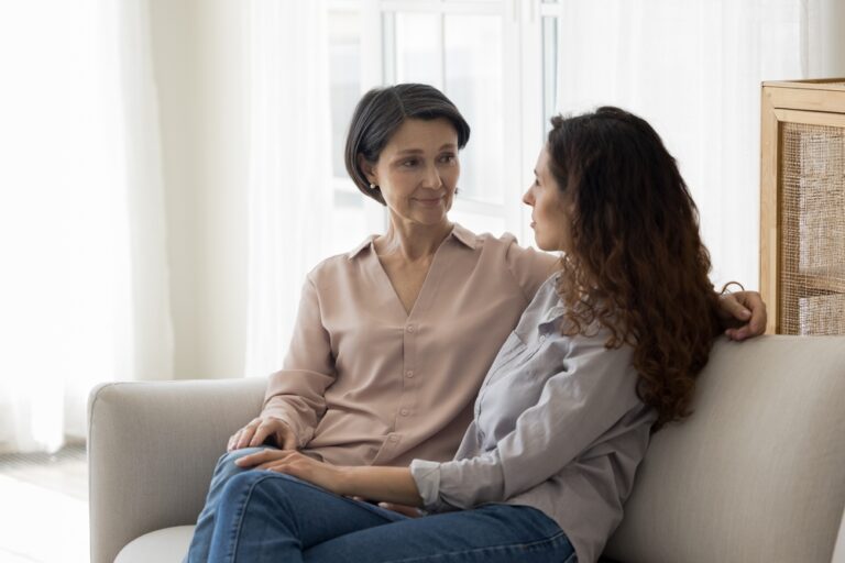 mom speaking to daughter woman on couch,